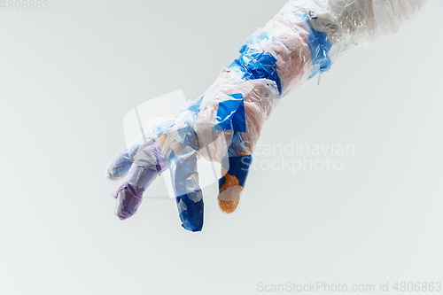 Image of Big plastic hand made of garbage isolated on white studio background