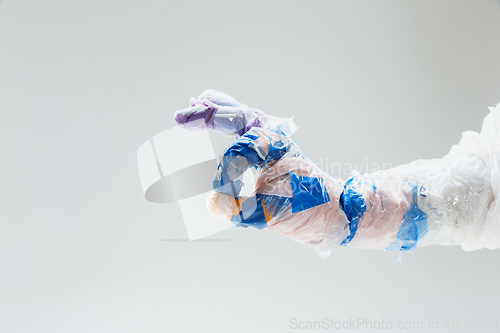 Image of Big plastic hand made of garbage isolated on white studio background