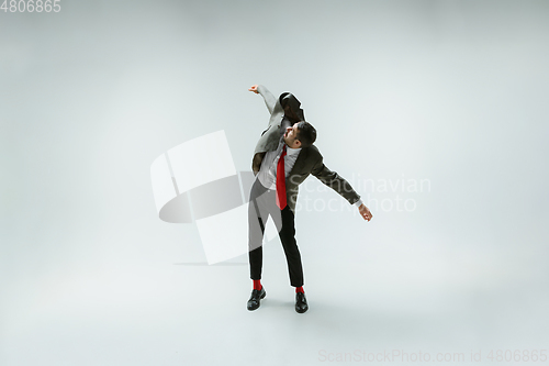 Image of Young caucasian man moving flexible on white studio background