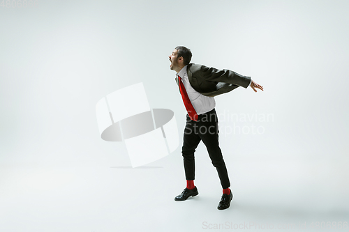 Image of Young caucasian man moving flexible on white studio background