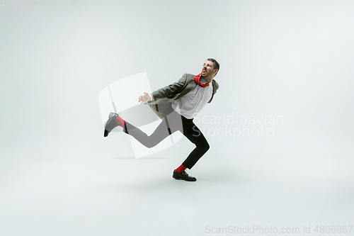 Image of Young caucasian man moving flexible on white studio background