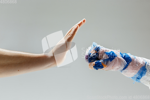 Image of Big plastic hand made of garbage with another one isolated on white studio background