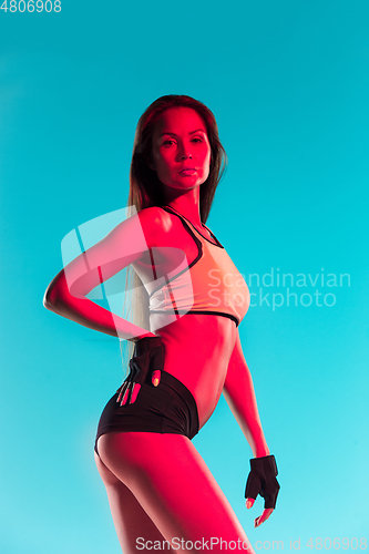 Image of Muscular young female athlete on blue background