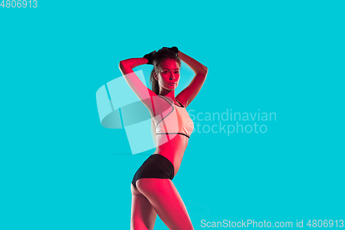 Image of Muscular young female athlete on blue background