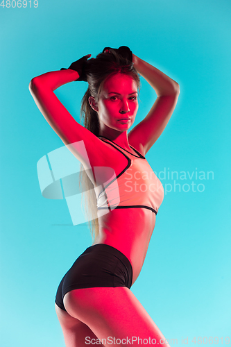 Image of Muscular young female athlete on blue background