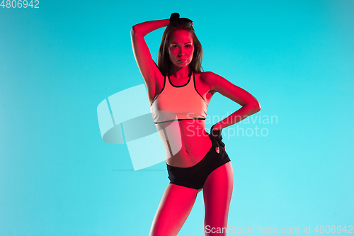 Image of Muscular young female athlete on blue background