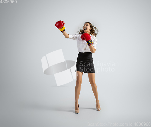 Image of Caucasian woman in office clothes boxing isolated on grey studio background