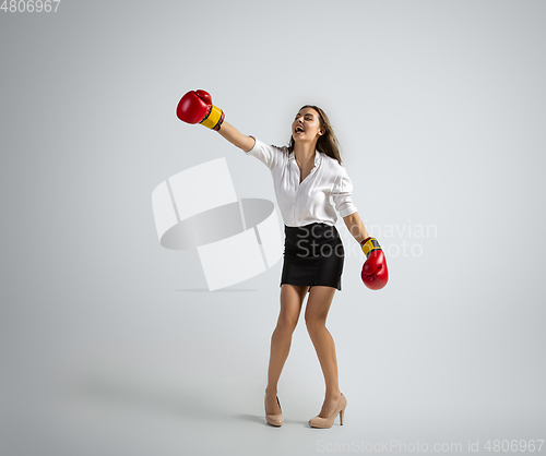 Image of Caucasian woman in office clothes boxing isolated on grey studio background