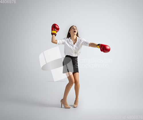 Image of Caucasian woman in office clothes boxing isolated on grey studio background