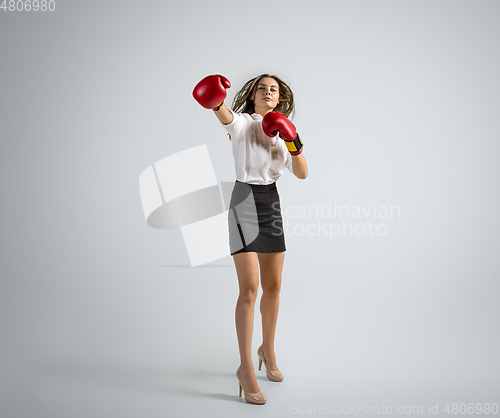 Image of Caucasian woman in office clothes boxing isolated on grey studio background