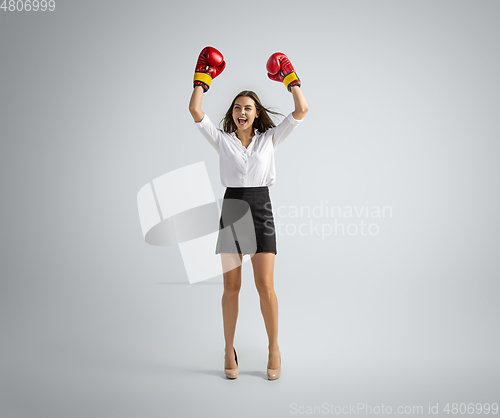 Image of Caucasian woman in office clothes boxing isolated on grey studio background