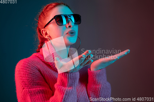 Image of Caucasian woman\'s portrait isolated on gradient studio background in neon light