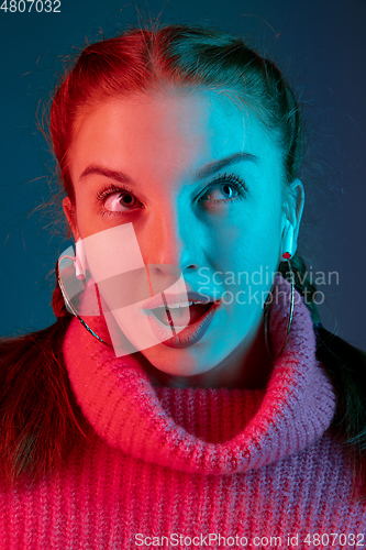 Image of Caucasian woman\'s portrait isolated on gradient studio background in neon light