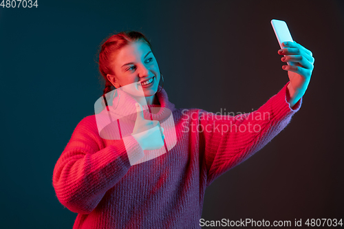 Image of Caucasian woman\'s portrait isolated on gradient studio background in neon light