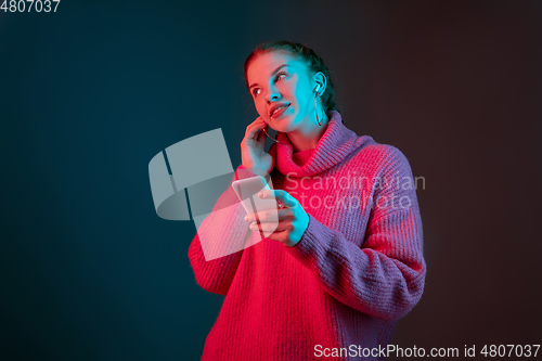 Image of Caucasian woman\'s portrait isolated on gradient studio background in neon light