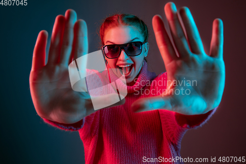 Image of Caucasian woman\'s portrait isolated on gradient studio background in neon light