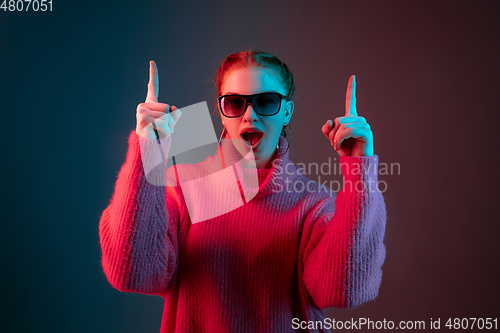 Image of Caucasian woman\'s portrait isolated on gradient studio background in neon light