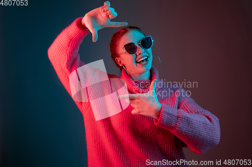 Image of Caucasian woman\'s portrait isolated on gradient studio background in neon light