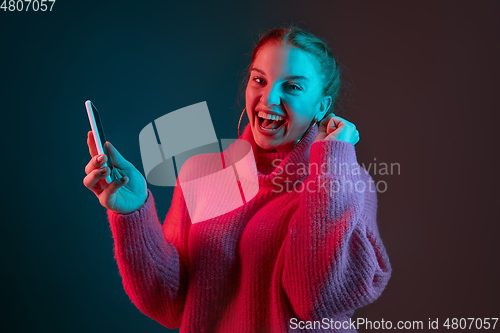 Image of Caucasian woman\'s portrait isolated on gradient studio background in neon light