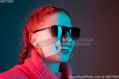Image of Caucasian woman\'s portrait isolated on gradient studio background in neon light