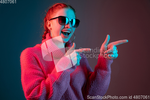 Image of Caucasian woman\'s portrait isolated on gradient studio background in neon light