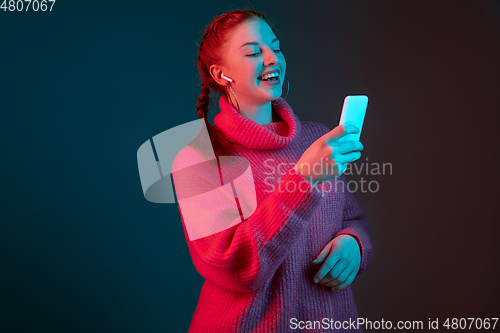 Image of Caucasian woman\'s portrait isolated on gradient studio background in neon light