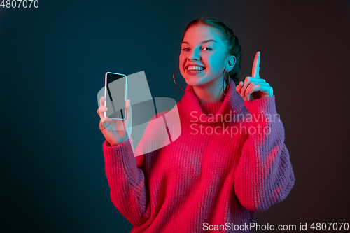 Image of Caucasian woman\'s portrait isolated on gradient studio background in neon light