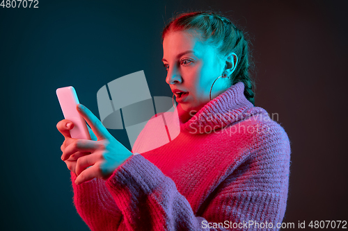 Image of Caucasian woman\'s portrait isolated on gradient studio background in neon light