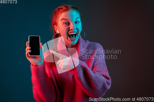 Image of Caucasian woman\'s portrait isolated on gradient studio background in neon light