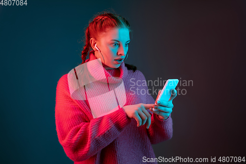 Image of Caucasian woman\'s portrait isolated on gradient studio background in neon light