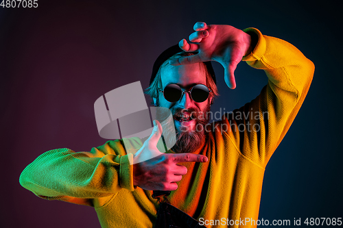 Image of Caucasian man\'s portrait isolated on gradient studio background in neon light
