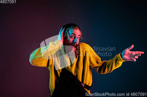 Image of Caucasian man\'s portrait isolated on gradient studio background in neon light
