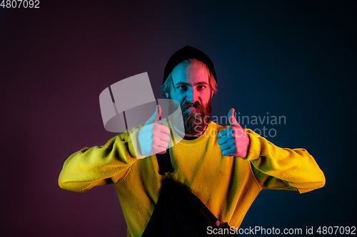 Image of Caucasian man\'s portrait isolated on gradient studio background in neon light