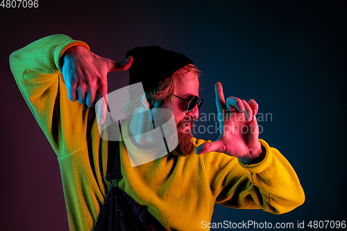 Image of Caucasian man\'s portrait isolated on gradient studio background in neon light