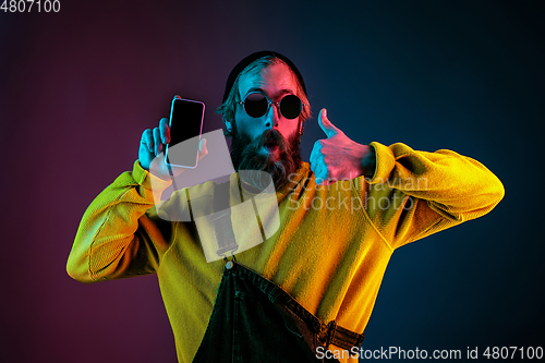 Image of Caucasian man\'s portrait isolated on gradient studio background in neon light