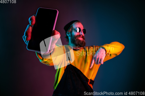 Image of Caucasian man\'s portrait isolated on gradient studio background in neon light