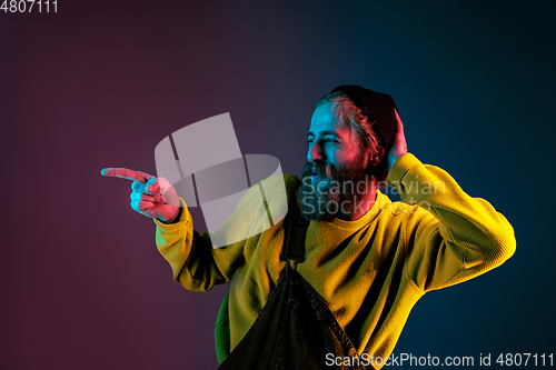 Image of Caucasian man\'s portrait isolated on gradient studio background in neon light