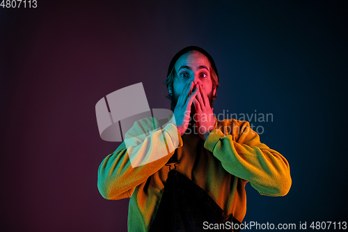 Image of Caucasian man\'s portrait isolated on gradient studio background in neon light
