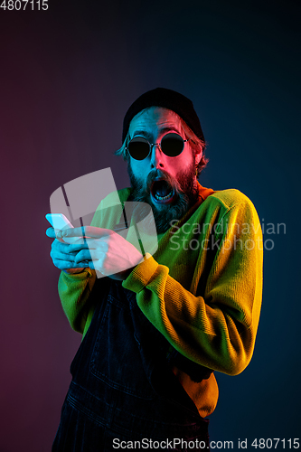 Image of Caucasian man\'s portrait isolated on gradient studio background in neon light