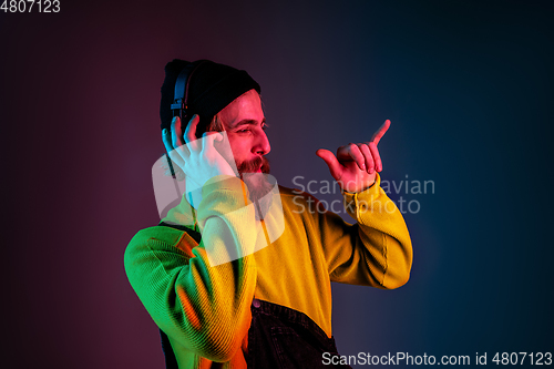 Image of Caucasian man\'s portrait isolated on gradient studio background in neon light