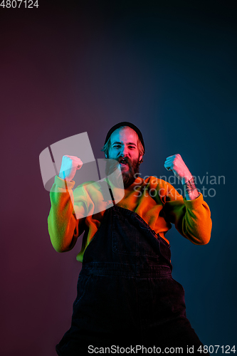 Image of Caucasian man\'s portrait isolated on gradient studio background in neon light