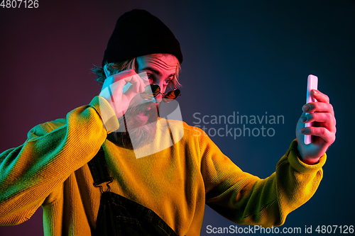 Image of Caucasian man\'s portrait isolated on gradient studio background in neon light