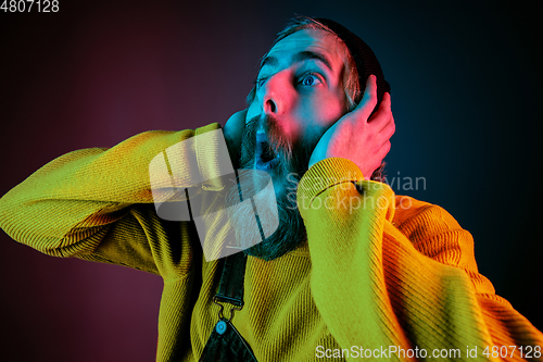 Image of Caucasian man\'s portrait isolated on gradient studio background in neon light