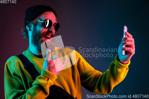 Image of Caucasian man\'s portrait isolated on gradient studio background in neon light