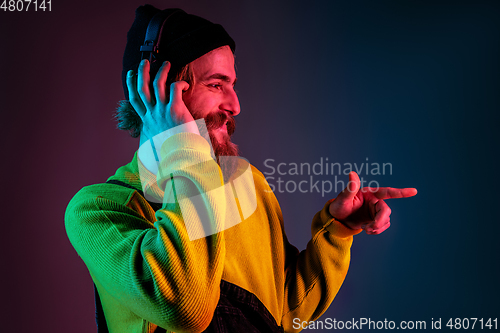 Image of Caucasian man\'s portrait isolated on gradient studio background in neon light