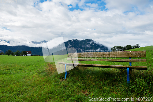 Image of A calm place to rest and relax. An empty wooden bench. Switzerland