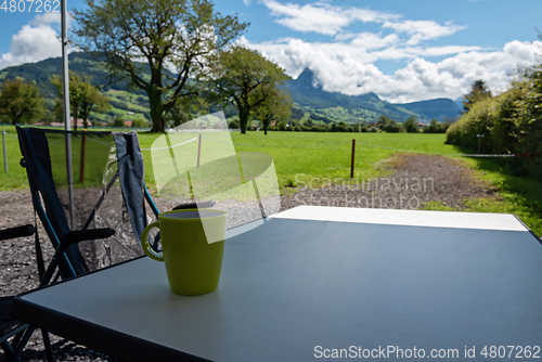 Image of Camping table and chairs in the Switzerland Alps. Great view. Outdoor camping concept