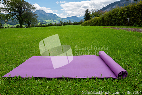 Image of Fitness mat on the green grass background