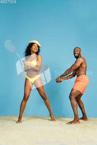 Image of Happy young couple resting on blue studio background