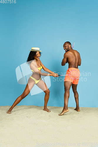 Image of Happy young couple resting on blue studio background